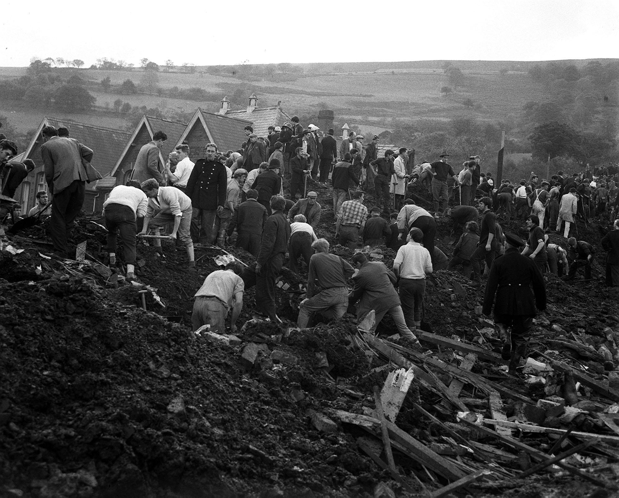 Working almost shoulder to shoulder, rescuers dig feverishly in the mud covering Pantglas Junior School at Aberfan, near Merthyr Tydfil, Glamorgan, as they try to reach the children trapped to-day (Friday) when the school was engulfed by a moving mountain